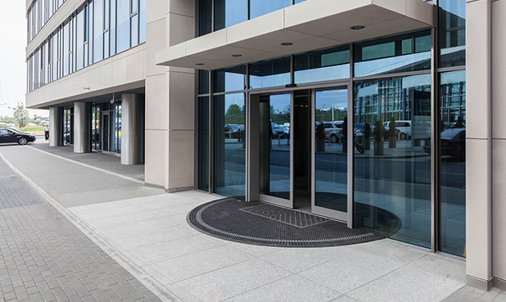 Concrete sidewalk and entry area at large office building.